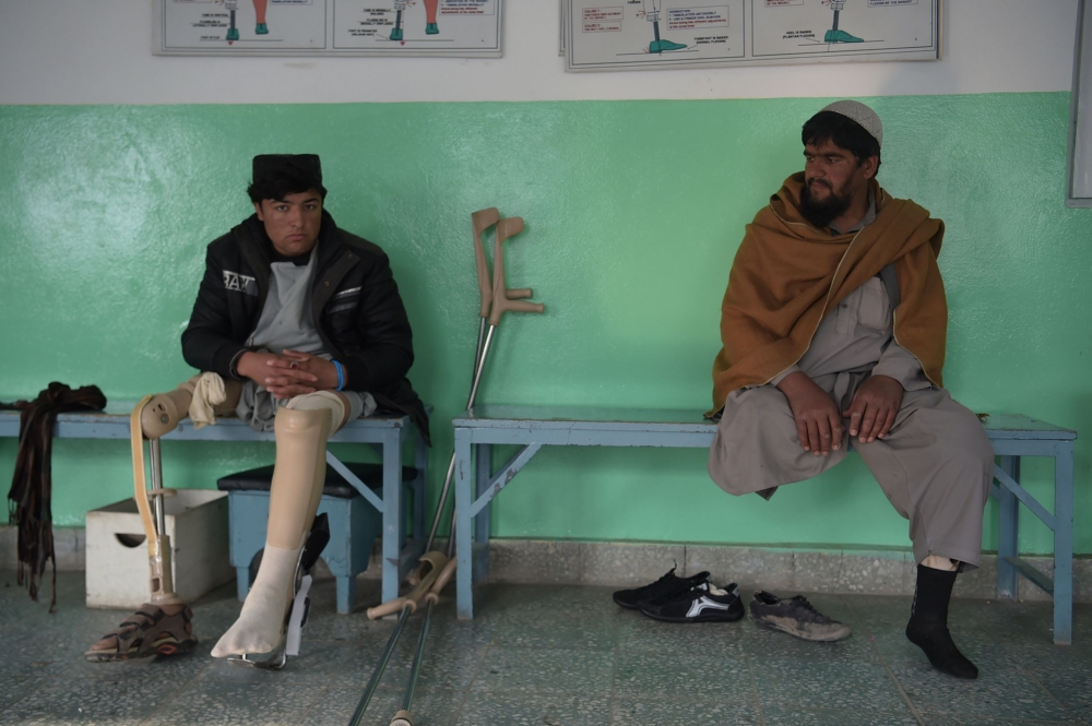 Afghan men who lost their legs due to landmines resting at a hospital run by the International Committee of the Red Cross (ICRC) for war victims and the disabled in Kabul. — AFP