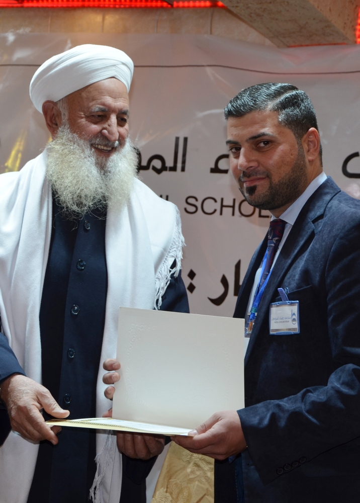 Ibrahim Al-Mashhadani, an Iraqi Muslim cleric distributes certificates during a graduation ceremony of the Muslim Scholars Forum of Mosul in the northern Iraqi city. Iraqi volunteers aged from 25 to 45 heralding from all sectors of society in Mosul, Iraq's second city and the former Daesh group's capital, including mechanics, teachers and a sheikh signed up for a week-long course run by Muslim Scholars Forum of Mosul on how to combat IS deviant ideology. — AFP
