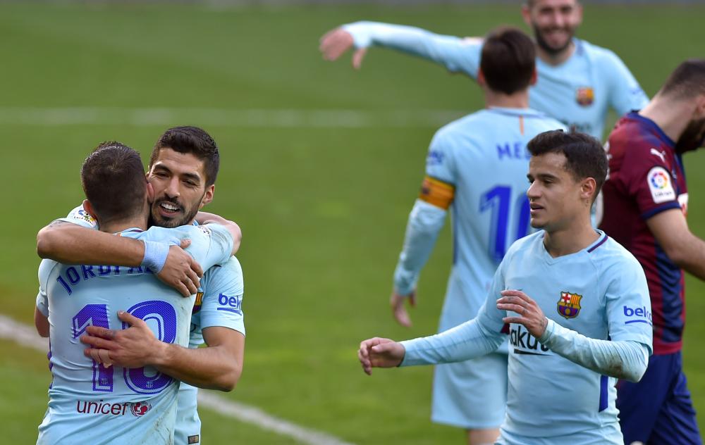 Barcelona's Luis Suarez (2nd L) congratulates Jordi Alba for his goal while Philippe Coutinho (R) approaches during their Spanish league football match against SD Eibar at the Ipurua Stadium in Eibar Saturday. — AFP