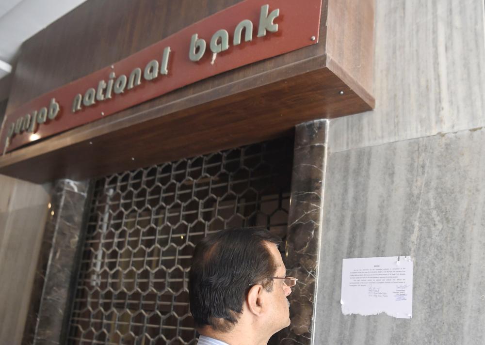 A man reads a notice by the Indian Central Bureau of Investigation (CBI) stating that the Brady House branch of the Punjab National Bank (PNB) has been sealed next to the entrance of the branch in Mumbai, India, on Monday. — AFP