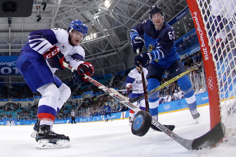 Finland's Sakari Manninen (R) scores past South Korea's Bryan William Young in the men's playoffs qualifications ice hockey match between Finland and South Korea during the Pyeongchang 2018 Winter Olympic Games at the Gangneung Hockey Centre in Gangneung on Tuesday. — AFP