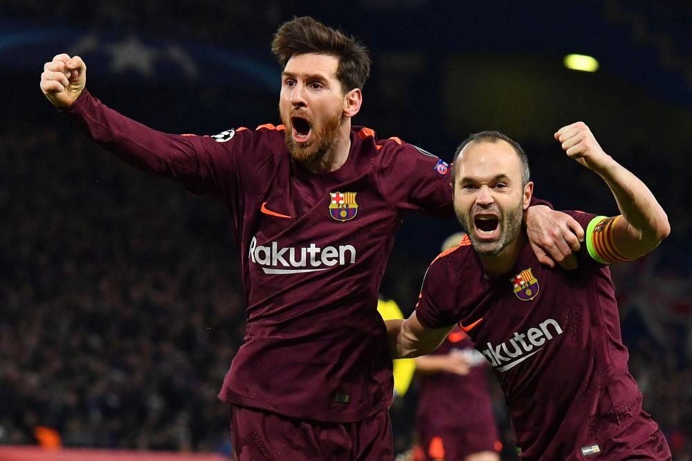 Barcelona’s Lionel Messi (L) celebrates with Andres Iniesta after scoring their equalizer during the first leg of the UEFA Champions League round of 16 match against Chelsea at Stamford Bridge Stadium in London Tuesday. — AFP