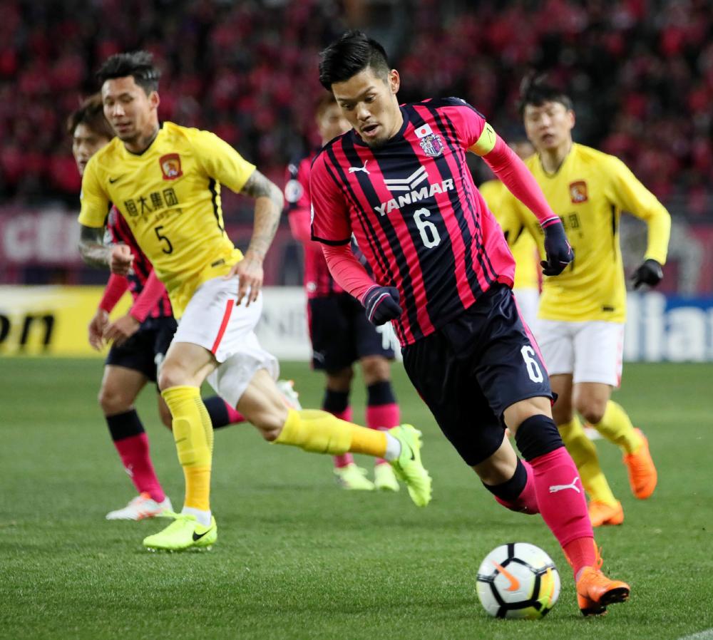 Hotaru Yamaguchi (R) of Japan's Cerezo Osaka controls the ball as Zhang Linpeng (L) of China's Guangzhou Evergrande looks on during their AFC Champions League match in Osaka Wednesday. — AFP
