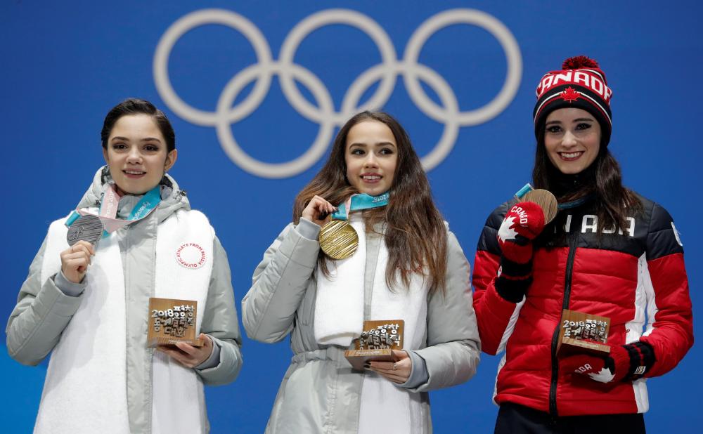 Gold medalist Alina Zagitova (C), an Olympic Athlete from Russia, silver medalist Evgenia Medvedeva (L), an Olympic Athlete from Russia, and bronze medalist Kaetlyn Osmond of Canada on the podium of the single skating at the Pyeongchang 2018 Winter Olympics Friday. — Reuters