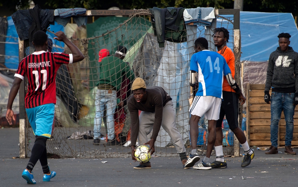 Sub-Saharan migrants play in a football match on a makeshift pitch in the middle of the Oulad Ziane migrant camp in Casablanca.  For the migrants in the Oulad Ziana migrant camp, who dream of one day crossing the Mediterranean to Europe, taking part in football games at the camp is a way to forget the tough situation they are in. — AFP photos