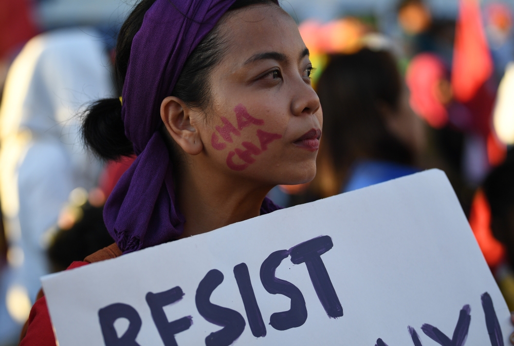 A protester holds a placard denouncing President Rodrigo Duterte march toward the ‘people power’ monument in Manila on Saturday, ahead of the ‘people power’ revolution anniversary that ousted the late dictator Ferdinand Marcos.— AFP