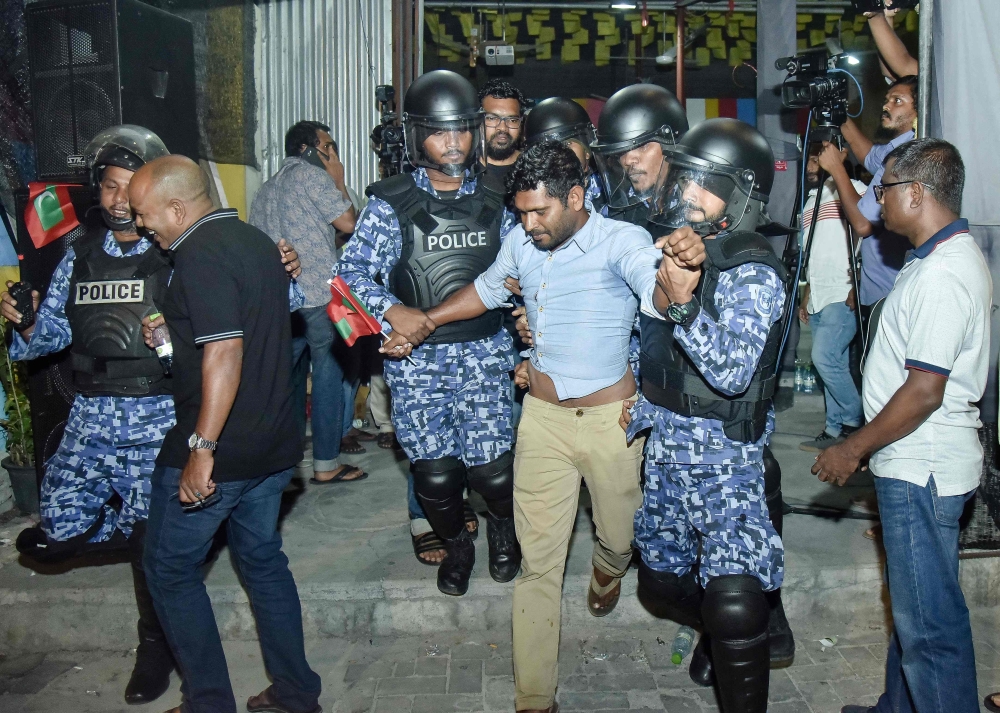 Maldivian police officers detain an opposition protester, center, demanding the release of political prisoners during a protest in Male in this Feb. 21, 2018 file photo. — AFP