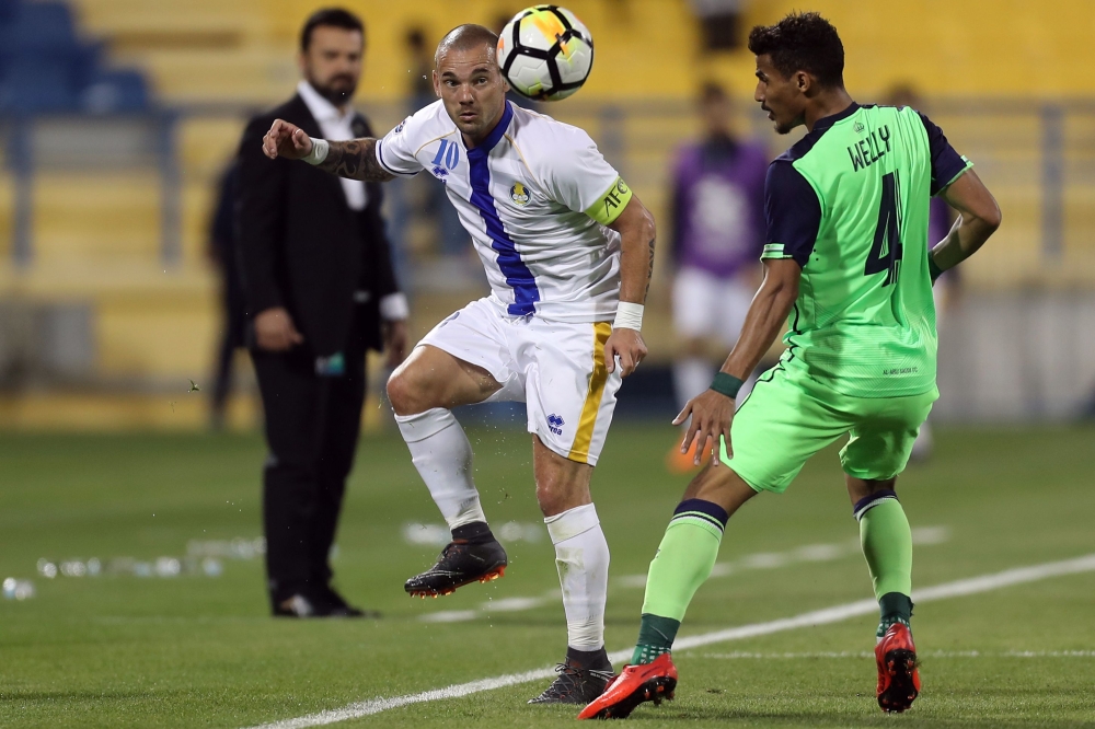 Al-Gharafa's midfielder Wesley Sneijder (L) controls the ball as he is marked by Al-Ahli's midfielder Waleed Bakshween during the AFC Champions League football match at the Thani Bin Jassim Stadium in Doha on Monday. — AFP