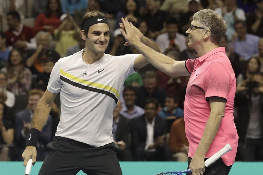 Roger Federer, of Switzerland, left, celebrates with partner Bill Gates as they play an exhibition tennis match against Jack Sock and Savannah Guthrie in San Jose, Calif., Monday. — AP