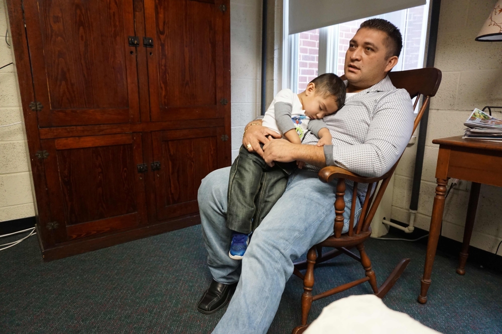 Business owner Oscar Canales holds his son, George, as he speaks during an interview at the Congregational United Church of Christ where he is living in sanctuary in Greensboro, North Carolina, in this Feb. 12, 2018 file photo. — AFP