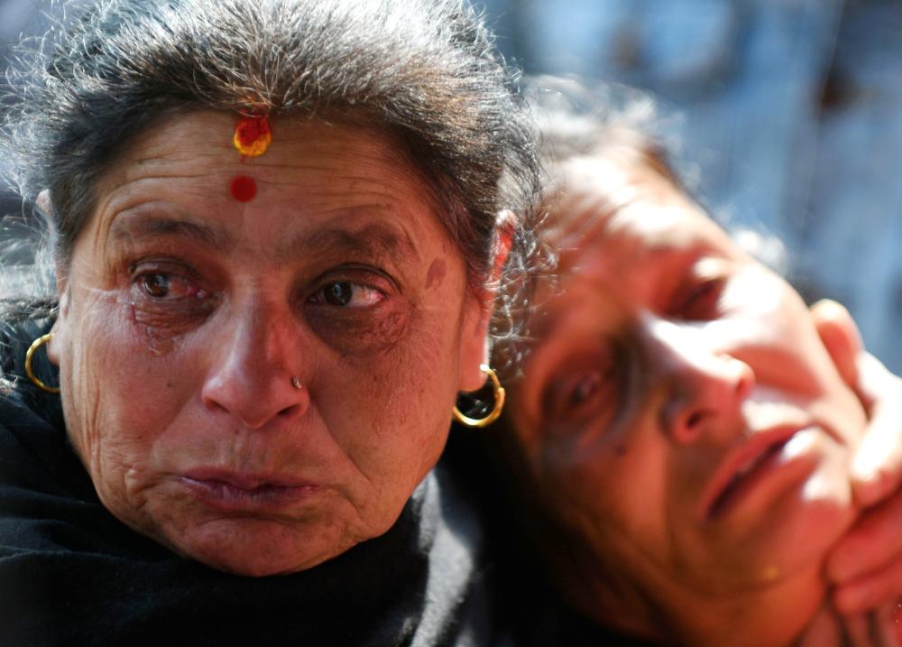 Family members of plane crash victims react outside a morgue at the Teaching Hospital in Kathmandu on Tuesday, a day after the deadly crash of a US-Bangla Airlines plane at the international airport. — AFP