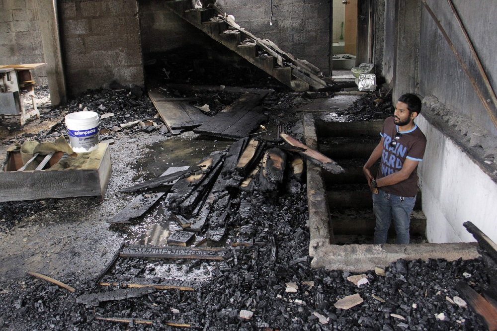 A man looks at a burned home a day after anti-Muslim riots erupted in Digana, a suburb of Kandy, in this March 7, 2018 file photo. — AFP