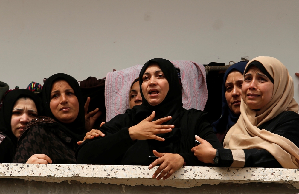 Relatives of Palestinian fisherman Ismail Abu Riyalah grieve for him at his funeral in Gaza City on Thursday. — Reuters