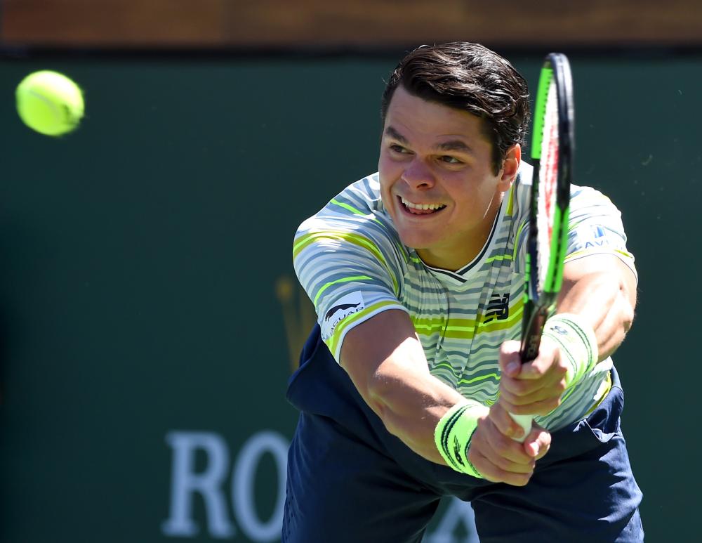 Milos Raonic of Canada returns to Sam Querrey of the US at the BNP Paribas Open in Indian Wells Friday. — Reuters