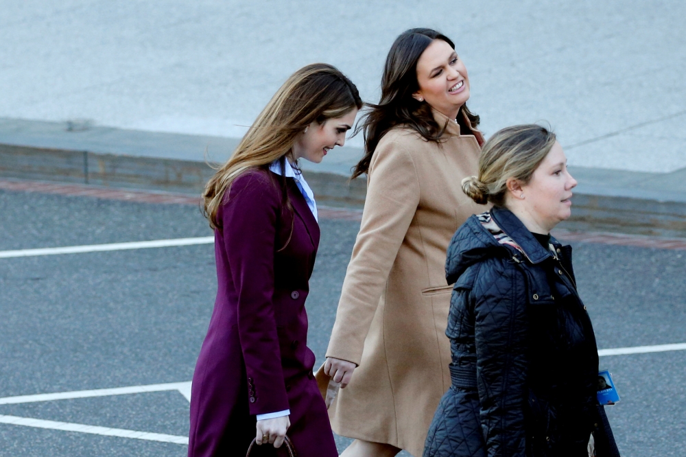 Outgoing White House Communications Director Hope Hicks, left, and White House Press Secretary Sarah Huckabee Sanders, second left, second left, chat as they depart the West Wing at the White House in Washington on Friday. — Reuters