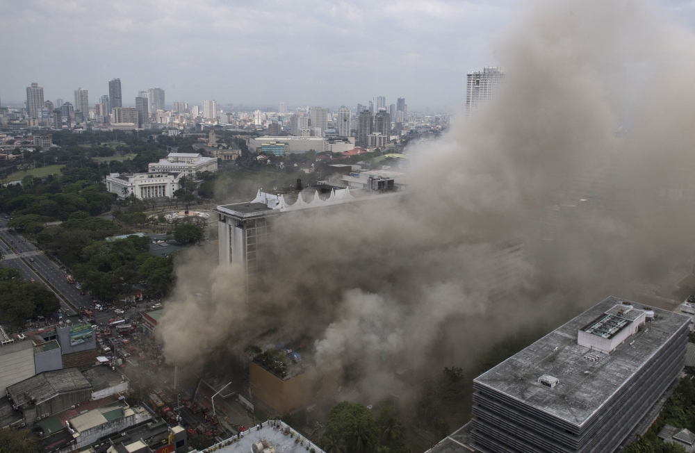 Heavy smoke engulfs the Waterfront Manila Pavilion building, after a fire broke out at the hotel in Manila on Sunday. — AFP