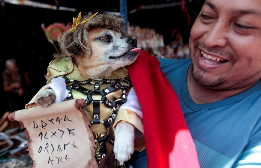 A man carries his dog during a mass in honor of Saint Lazarus in the indigenous community of Monimbo in Masaya, Nicaragua on Monday. - Reuters