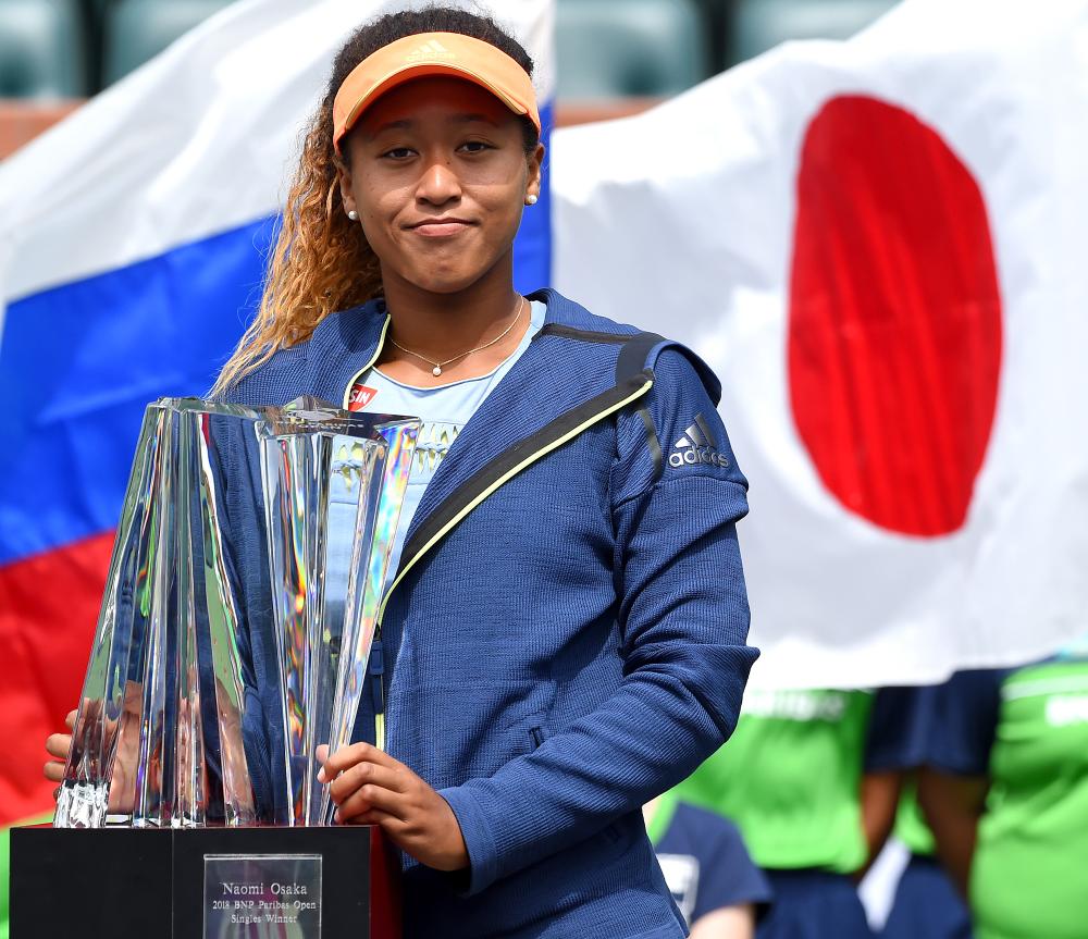 Naomi Osaka of Japan holds the championship trophy after defeating Daria Kasatkina of Russia at the BNP Paribas Open in Indian Wells Sunday. — Reuters 