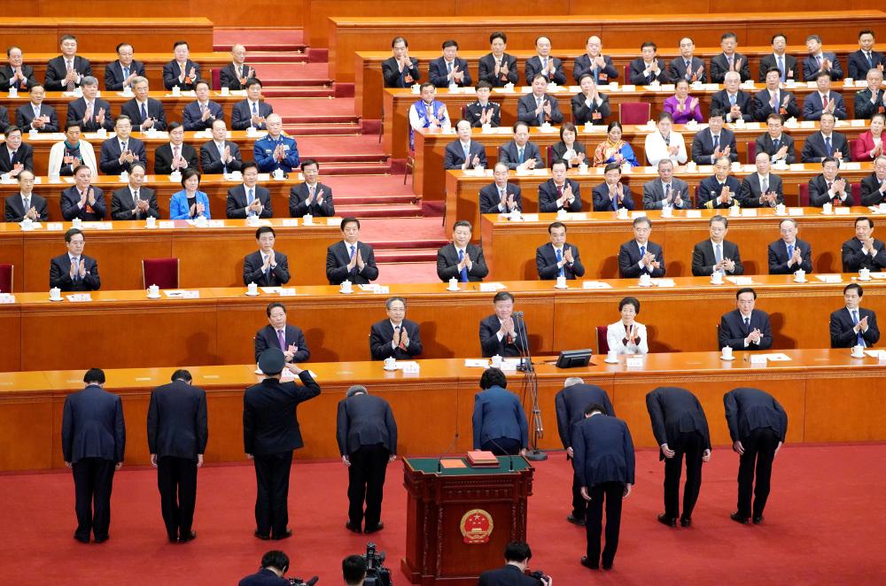 Newly elected vice premiers and state Councillors make a bow to Chinese President Xi Jinping and other officials after an oath-taking session at the seventh plenary session of the National People’s Congress (NPC) at the Great Hall of the People in Beijing on Monday. — Reuters