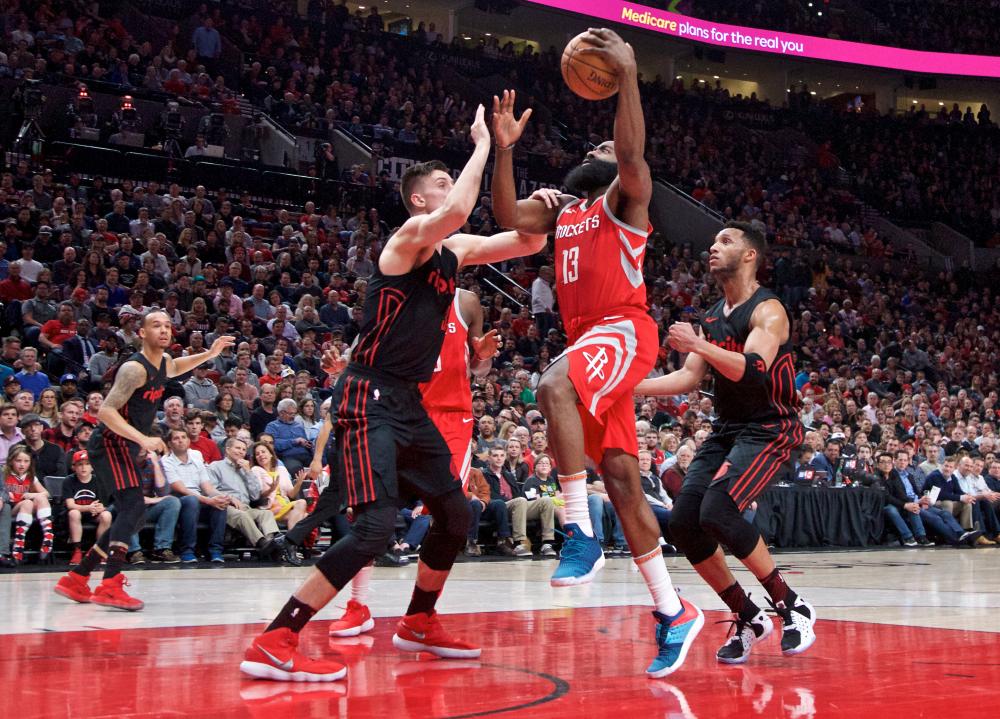 Houston Rockets’ guard James Harden shoots over Portland Trail Blazers’ center Zach Collins and forward Evan Turner during their NBA game at the Moda Center in Portland Tuesday. — Reuters