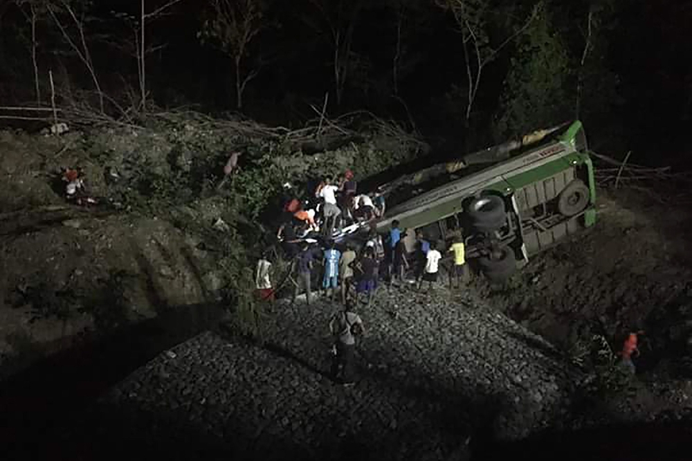 People and rescuers search for survivors after a passenger bus plunged off a cliff in Sablayan town, Occidental Mindoro province, south of Manila, on Tuesday. — AFP