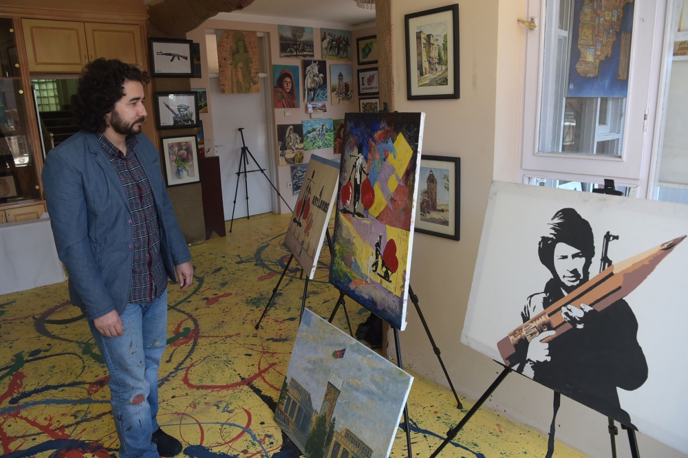 Artlords co-founder and president Omaid Sharifi looks at paintings during an interview in Kabul in this March 15, 2018 file photo. — AFP