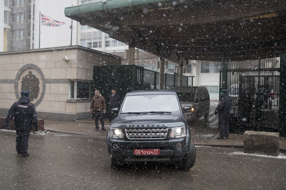 Vehicles allegedly carrying British diplomats expelled by Russia, leave the British Embassy in Moscow, on Friday. — AP