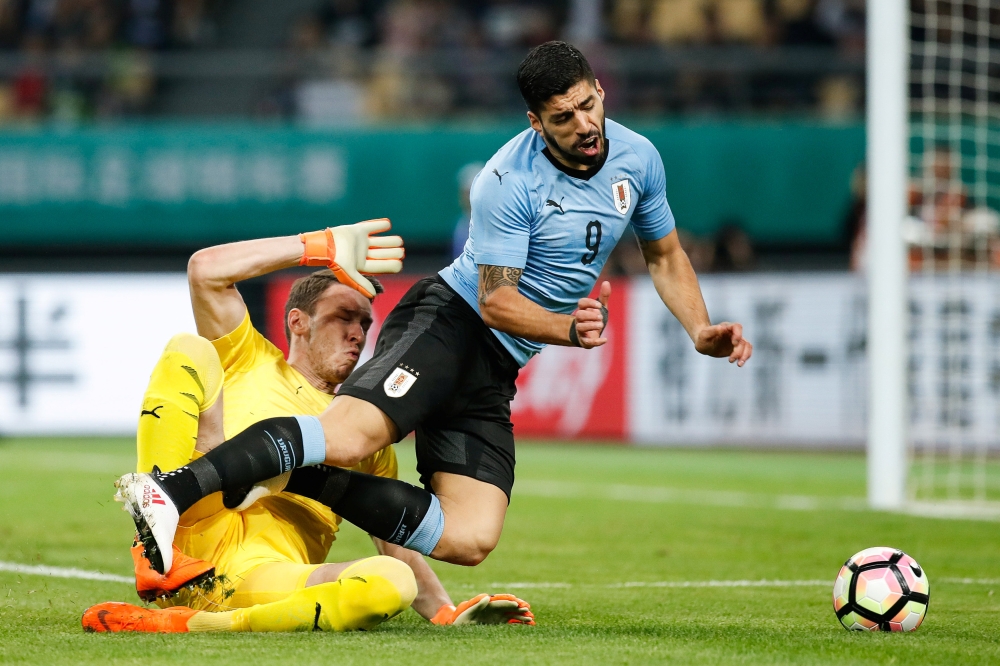 Jiri Pavlenka of Czech Republic and Luis Suarez of Uruguay in action during the China Cup semifinals at Guangxi Sports Center, Nanning, China, on Friday. — Reuters