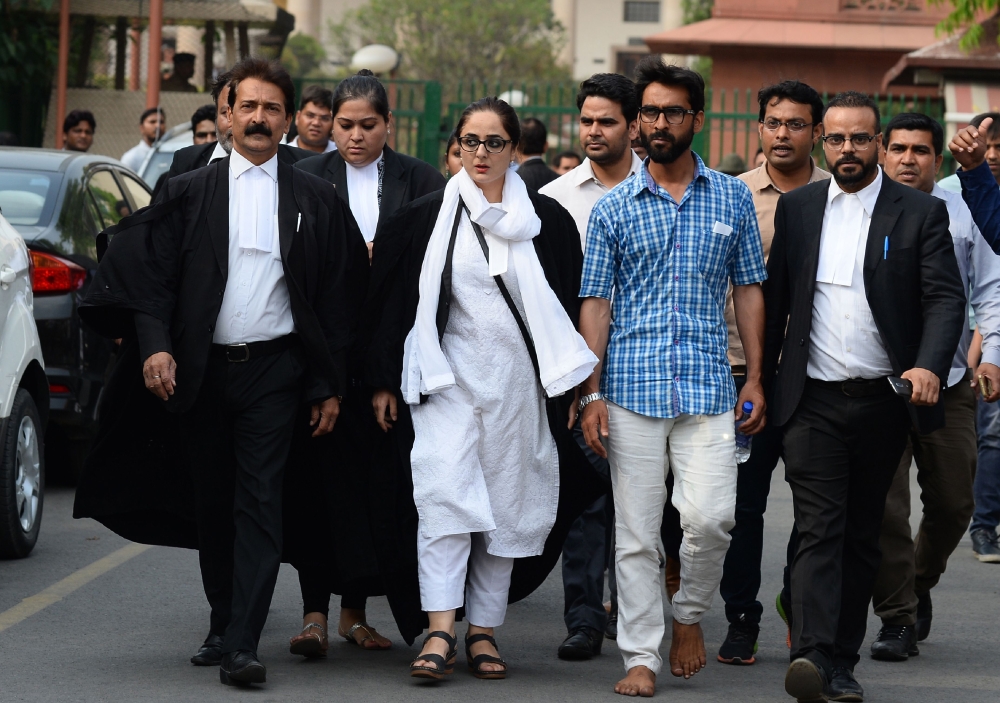 Indian lawyer Deepika Singh Rajawat, center, counsel for the family of a young girl who was raped and murdered, walks outside the Supreme Court to address the media in New Delhi on Monday. — AFP