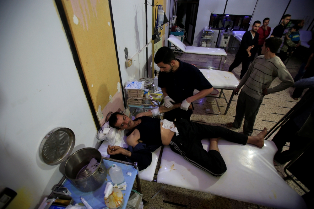 An injured man lies on a bed at an underground field hospital at the city of Douma in Damascus. — Reuters