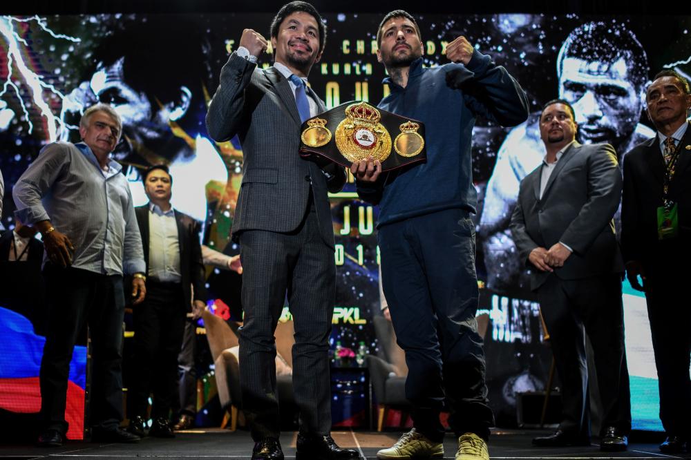 Filipino boxing idol Manny Pacquiao (L) poses for photographs with Argentina’s Lucas Matthysse after a press conference in Kuala Lumpur, ahead of their world welterweight boxing championship bout in July. — AFP 