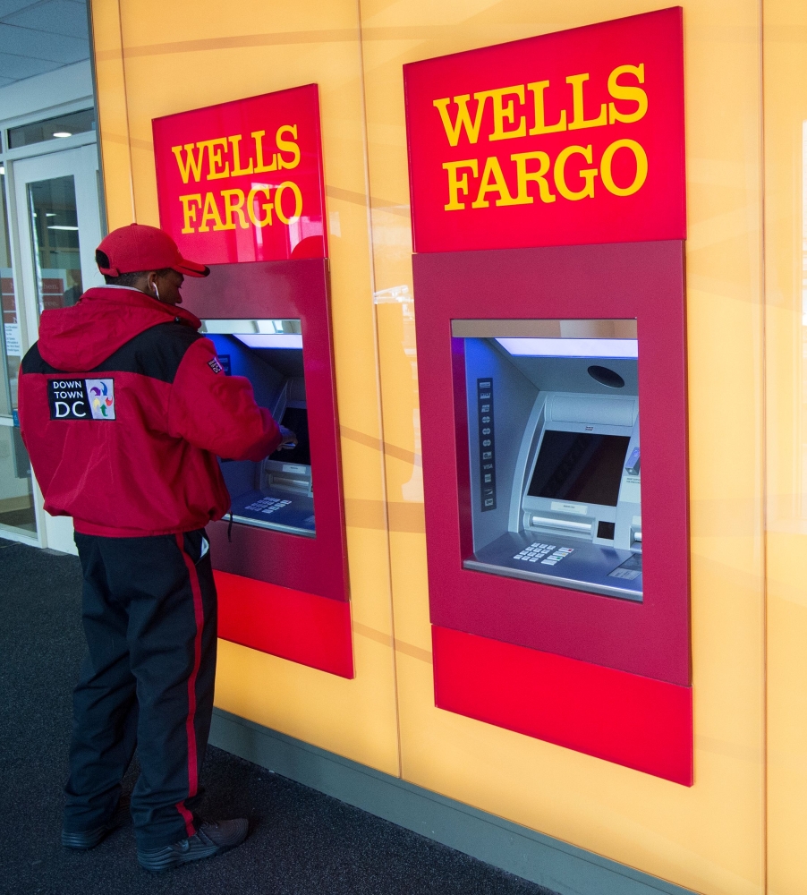 In this file photo a banking customer uses an ATM at Wells Fargo in Washington, DC. Wells Fargo will pay $1 billion in fines to address deficiencies identified by regulators in its mortgage and auto loan businesses, US regulators said Friday. — AFP