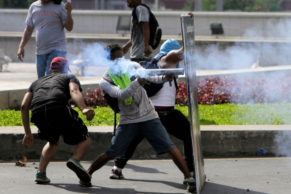 Students clash with riot police, during a protest against the government’s reforms in the Institute of Social Security (INSS) in Managua on Friday. — AFP