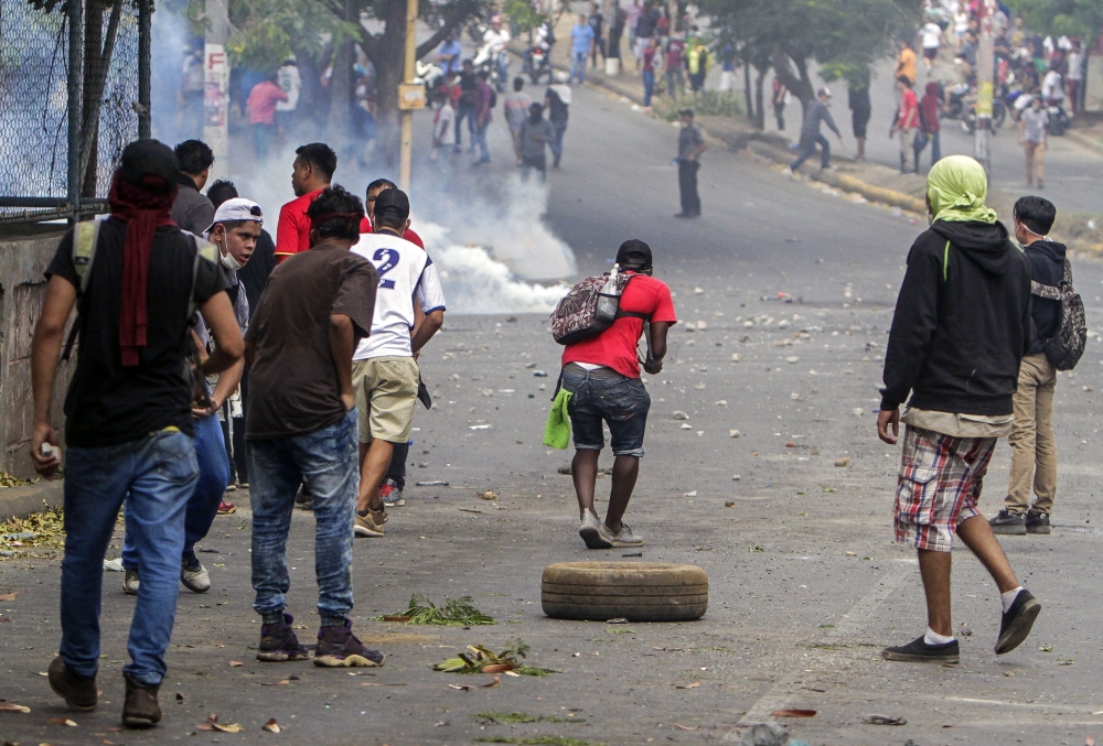 Students clash with riot police agents close to Nicaragua’s Technical College during a protest against government’s reforms in the Institute of Social Security (INSS) in Managua on Saturday. — AFP