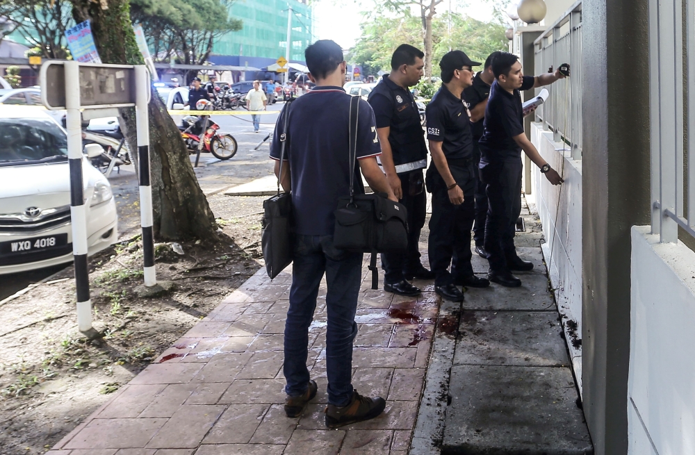 Malaysian forensic police collect evidence in the area where a Palestinian scientist was assassinated in Kuala Lumpur on Saturday. — AFP