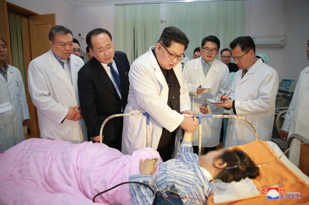 Kim Jong-un, center, chairman of the Workers' Party of Korea and chairman of the State Affairs Commission of the Democratic People’s Republic of Korea, visits a victim of a traffic accident that claimed heavy causalities among Chinese tourists to the DPRK, in Pyongyang, North Korea, on Monday. — EPA