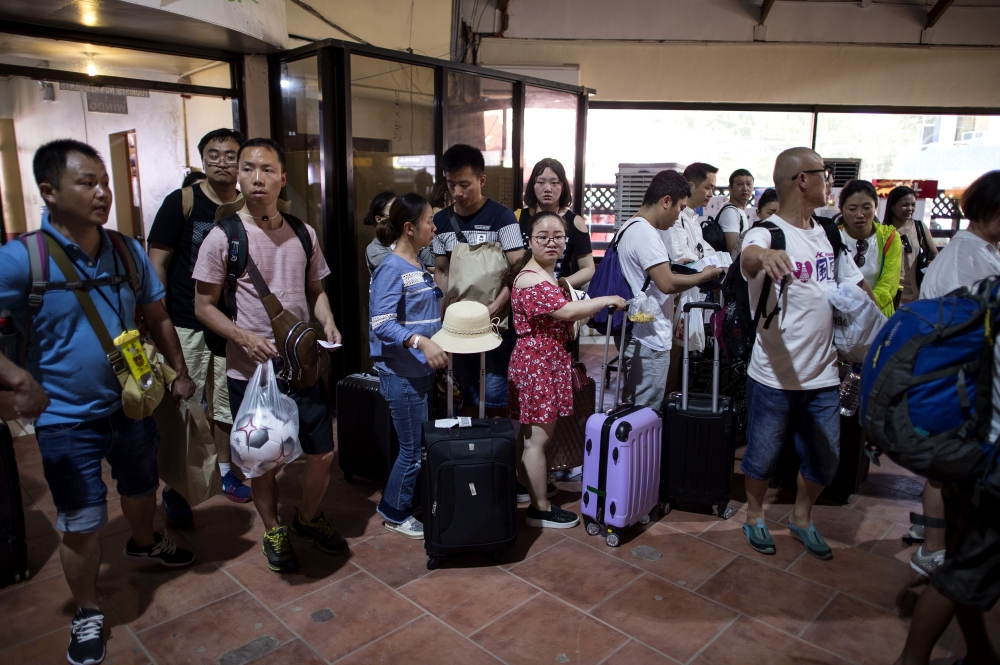 Tourists queue at a jetty to board a boat leaving the Philippine island of Boracay on Wednesday. — AFP