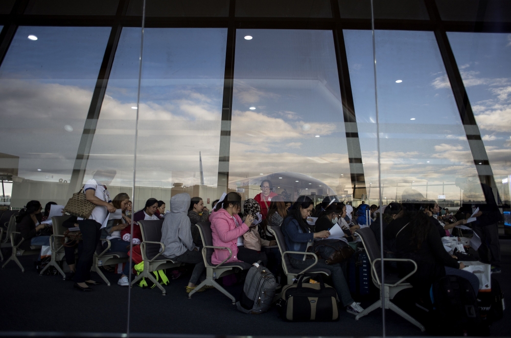 In this file photo taken on Feb. 18, 2018, Filipina workers returning home from Kuwait fill out forms upon their arrival at Manila International Airport. — AFP