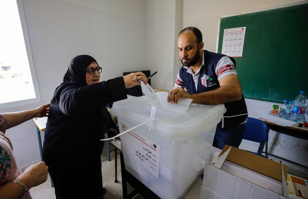 An elderly Lebanese woman casts her ballot in a box as she votes in the first parliamentary election in nine years, in the northern port city of Tripoli on Sunday. — AFP