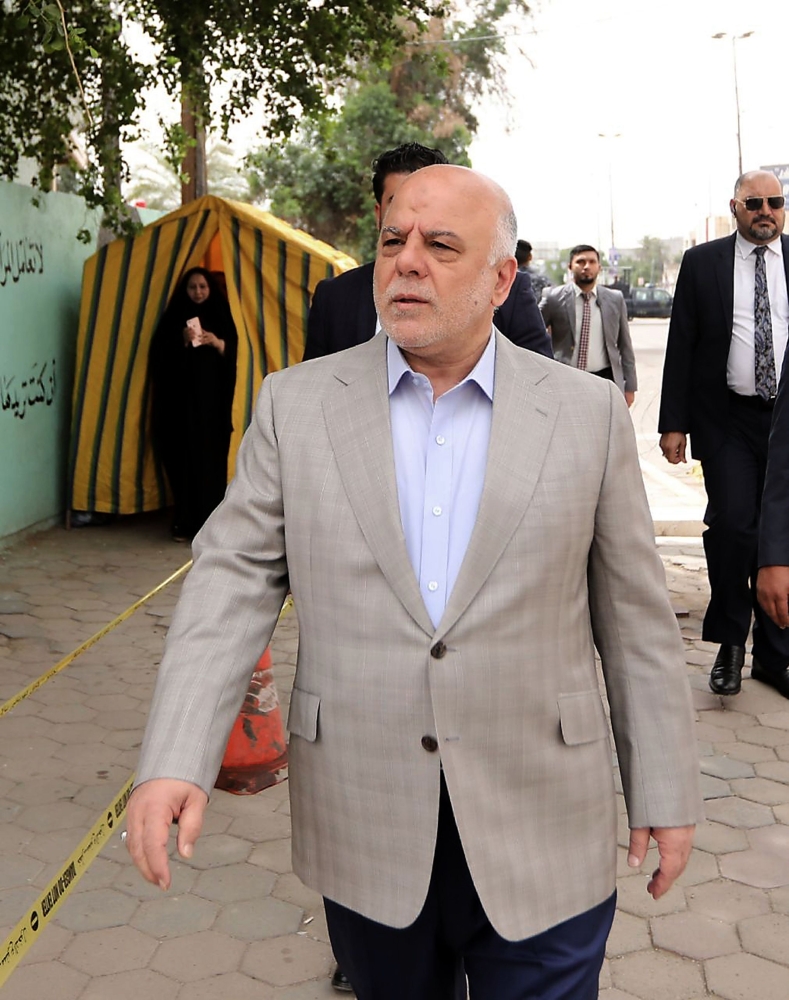 A handout picture released by Iraq's Prime Minister's Media Office on Saturday shows PM Haider Al-Abadi arriving at a poll station in the capital Baghdad's Karrada district. — AFP