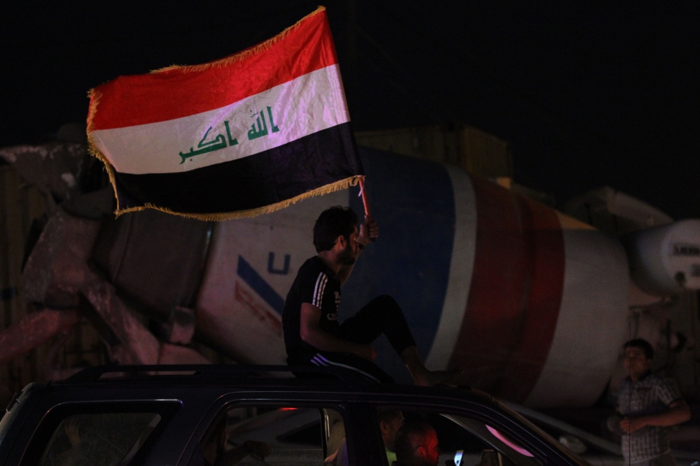 Iraqi men celebrate in Baghdad on Monday. The race to become Iraq's next prime minister appeared wide open as two outsider alliances looked to be in the lead after the first elections since the defeat of the Daesh group. — AFP