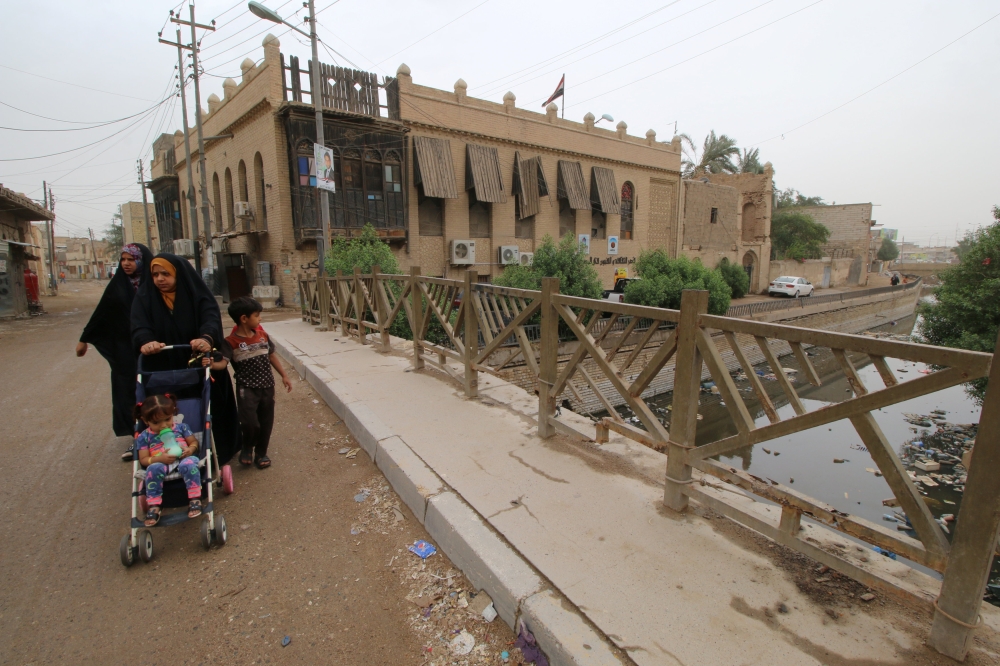 People walk near one of the ancient historic houses dated back to the time of Ottomans in the old downtown of Basra. — Reuters