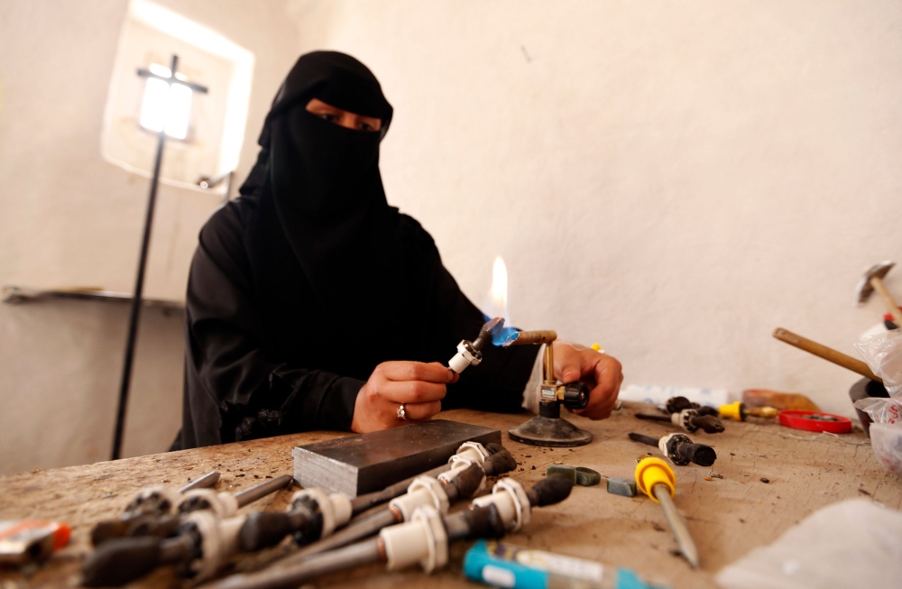 Safaa Al-Faqih, one of the few female Yemeni craftsmen working in the precious stones industry in Yemen, crafts a stone in the old city of the capital, Sanaa. — AFP