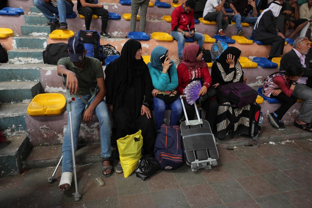 Palestinians wait to travel to Egypt through the Rafah border crossing, in the southern Gaza Strip, Friday. Egyptian President Abdel Fattah El-Sisi has made a rare decision to open the Rafah crossing with Gaza for a month, allowing Palestinians to cross during the holy period of Ramadan. — AFP
