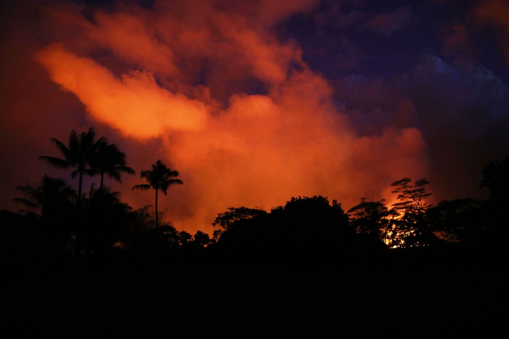Clouds glow orange-red above a lava flow from a Kilauea volcano fissure on Hawaii‘s Big Island in Kapoho, Hawaii, on Saturday. — AFP