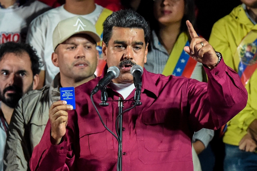 Venezuelan President Nicolas Maduro holds the political constitution after the National Electoral Council (CNE) announced the results of the voting on presidential election in Caracas, Venezuela, on Sunday. — AFP