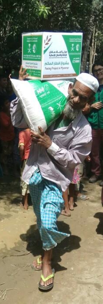An elderly man in Myanmar’s Rakhine state carries a food basket and relief material he received from the King Salman Humanitarian Aid and Relief Center (KSRelief). — SPA