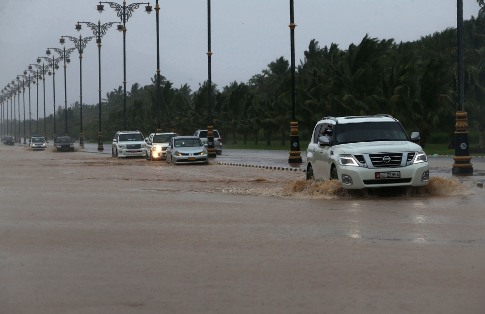 Cars drive through a flooded street in Salalah in Oman as Cyclone Mekunu hit the country on Friday. — AFP