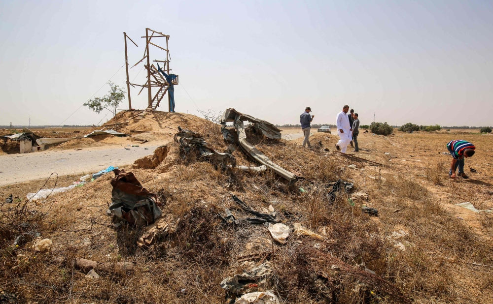 Palestinians inspect damage at an observation post which was hit by Israeli tank fire earlier in the day that left two Palestinian youths killed, east of the city of Rafah in the southern Gaza strip on Sunday. — AFP
