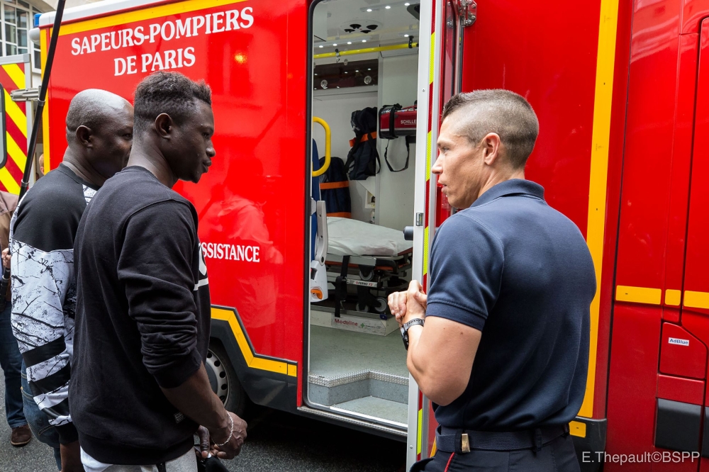 Mamoudou Gassama, second left, visits the Paris Fire Brigade headquarters and Champerret fire station in Paris on Tuesday. — AFP